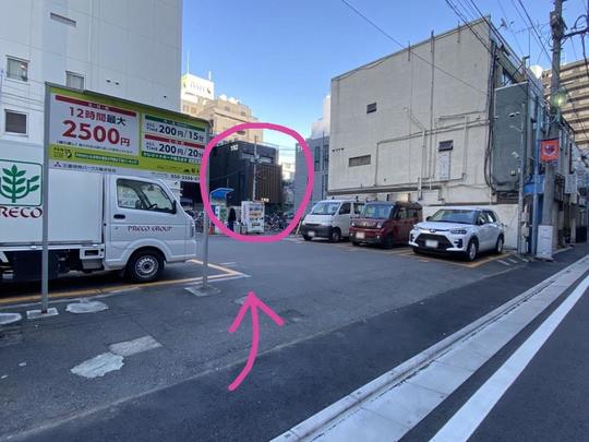 左手の駐車場・自転車置き場の奥にあるTMOビル（相談ルームの入居建物）外観